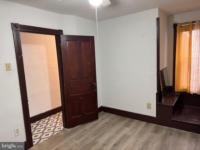 spare room with light wood finished floors, baseboards, and a ceiling fan