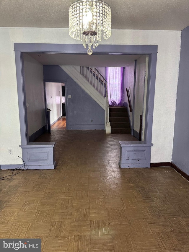 entryway with a chandelier, stairs, and baseboards