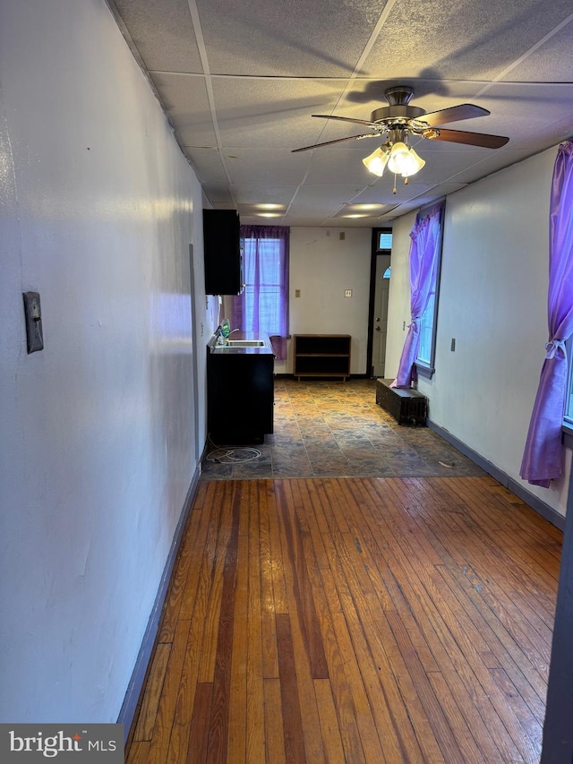 hallway featuring hardwood / wood-style floors and baseboards
