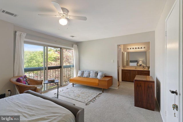bedroom with a ceiling fan, visible vents, light carpet, and ensuite bath