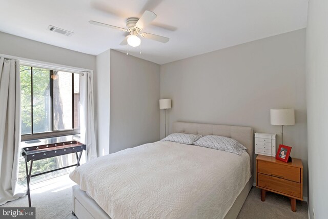 carpeted bedroom featuring ceiling fan and visible vents