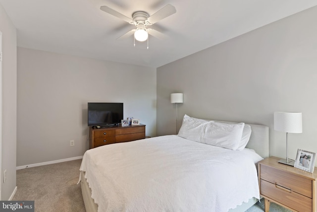 bedroom with a ceiling fan, baseboards, and light colored carpet