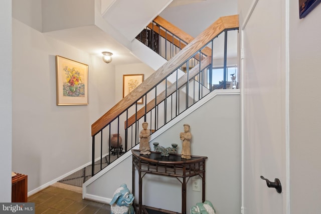 staircase featuring baseboards and tile patterned flooring