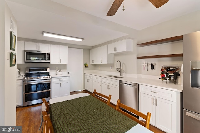 kitchen with open shelves, a sink, light countertops, stainless steel appliances, and white cabinetry