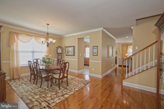 dining room with a wealth of natural light, hardwood / wood-style flooring, and ornamental molding