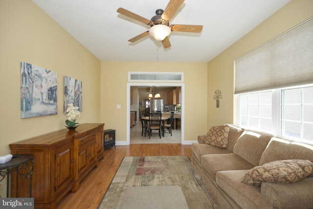 living room with ceiling fan, light wood finished floors, and baseboards
