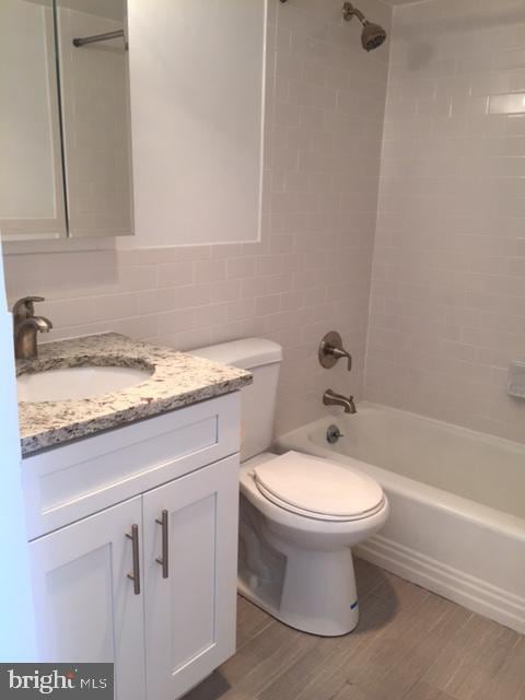224 W Rittenhouse Sq Unit 2015B, Philadelphia, PA 19103 - full bath with wood finished floors, toilet, vanity, tile walls, and shower / tub combination