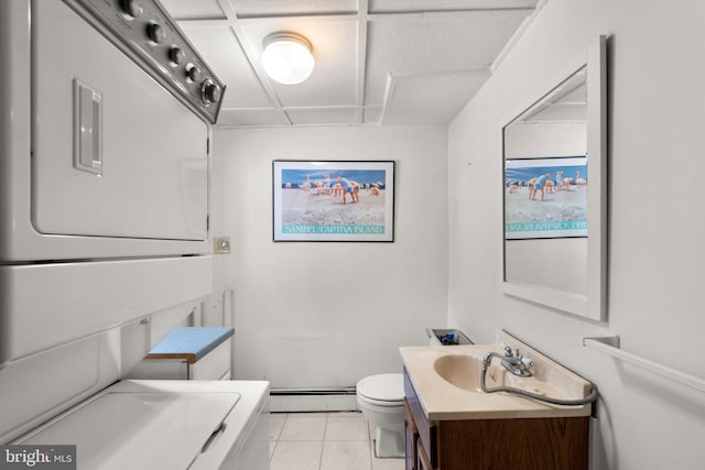 bathroom featuring stacked washer and dryer, tile patterned flooring, vanity, a baseboard radiator, and toilet
