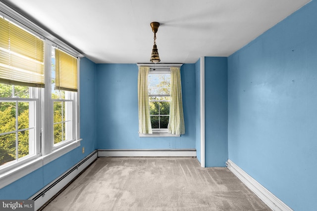 empty room with carpet floors, a baseboard radiator, and a healthy amount of sunlight
