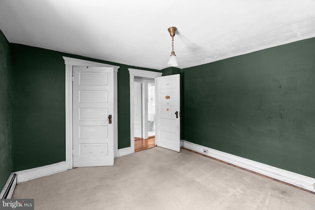 unfurnished bedroom featuring carpet flooring, baseboards, and baseboard heating