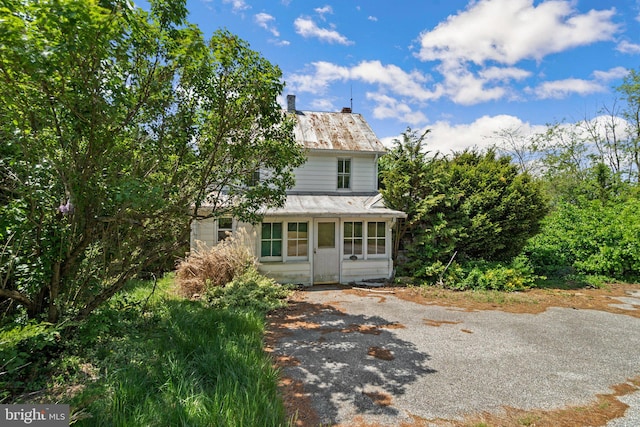 view of front of property with a chimney and aphalt driveway