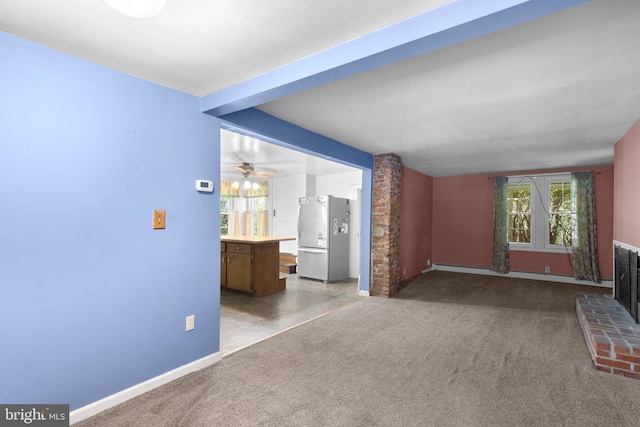 unfurnished living room with baseboards, carpet, and a fireplace