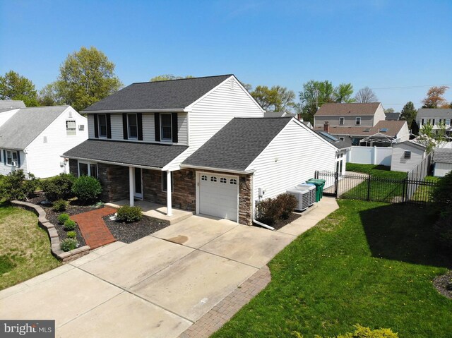 traditional home with a porch, a front lawn, a garage, roof with shingles, and fence