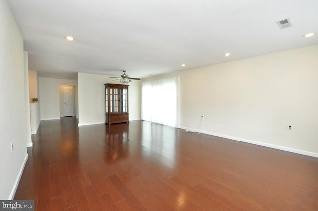 unfurnished room featuring dark wood-style flooring, a ceiling fan, baseboards, recessed lighting, and visible vents