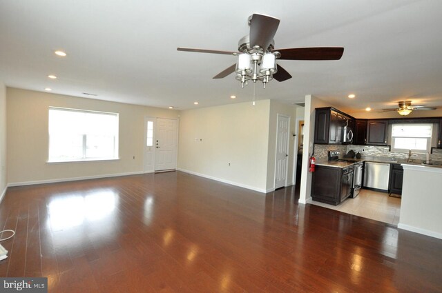 unfurnished living room with a ceiling fan, baseboards, recessed lighting, and light wood-style flooring