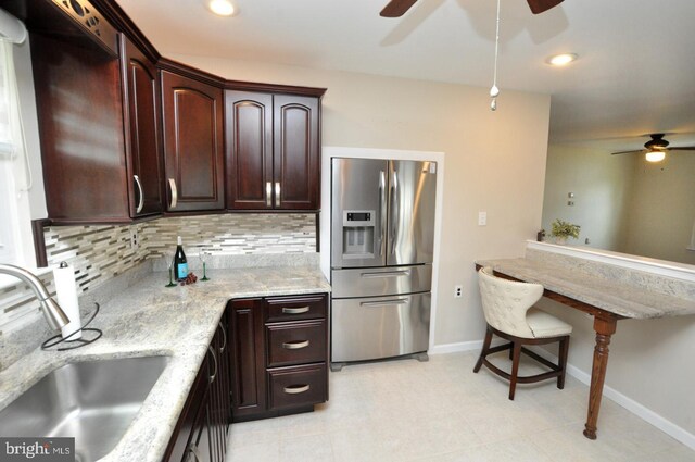 kitchen featuring stainless steel refrigerator with ice dispenser, a sink, decorative backsplash, and ceiling fan