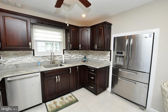 kitchen featuring ceiling fan, appliances with stainless steel finishes, tasteful backsplash, dark brown cabinets, and a sink