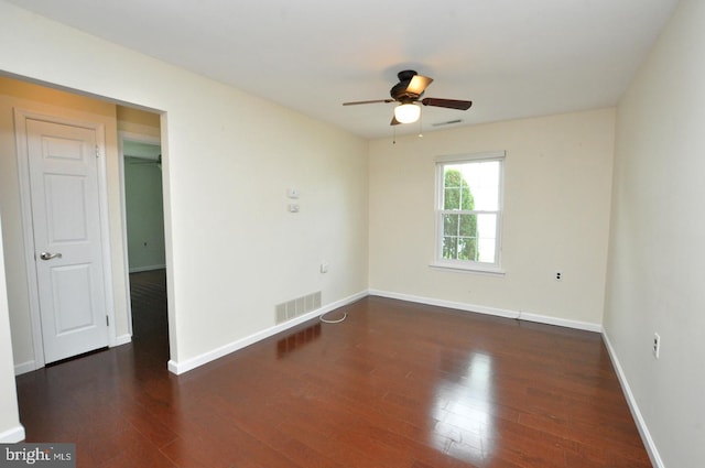 empty room featuring visible vents, a ceiling fan, baseboards, and wood finished floors