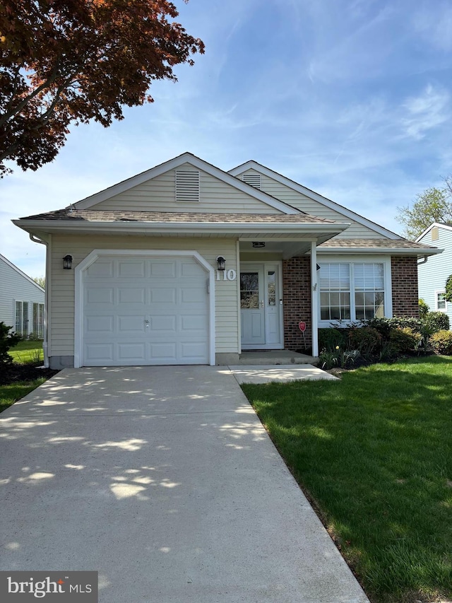 single story home featuring brick siding, a garage, a front lawn, and concrete driveway
