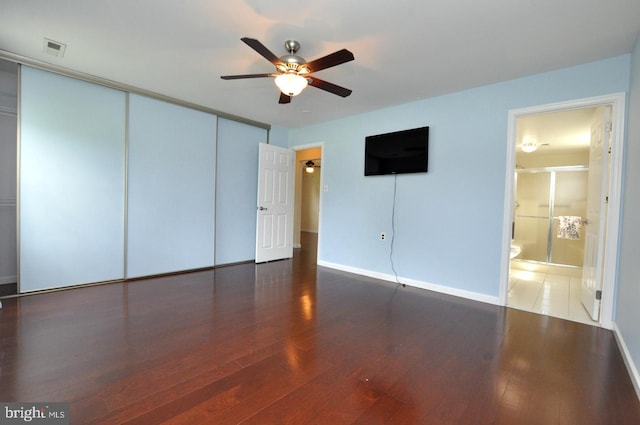 unfurnished bedroom with baseboards, a closet, wood finished floors, and visible vents