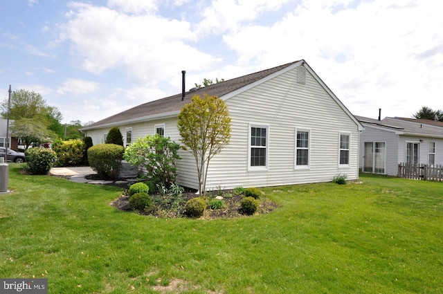 view of side of home with a lawn