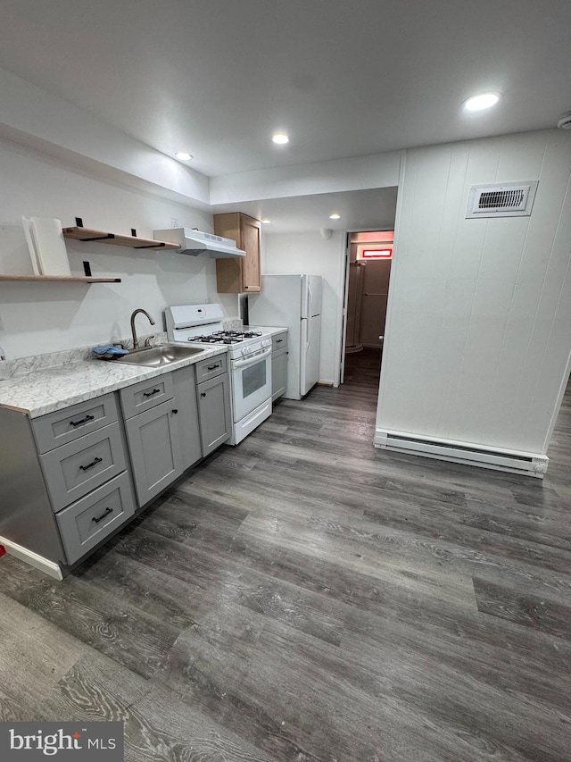 kitchen with white appliances, gray cabinetry, baseboard heating, dark wood-type flooring, and a sink