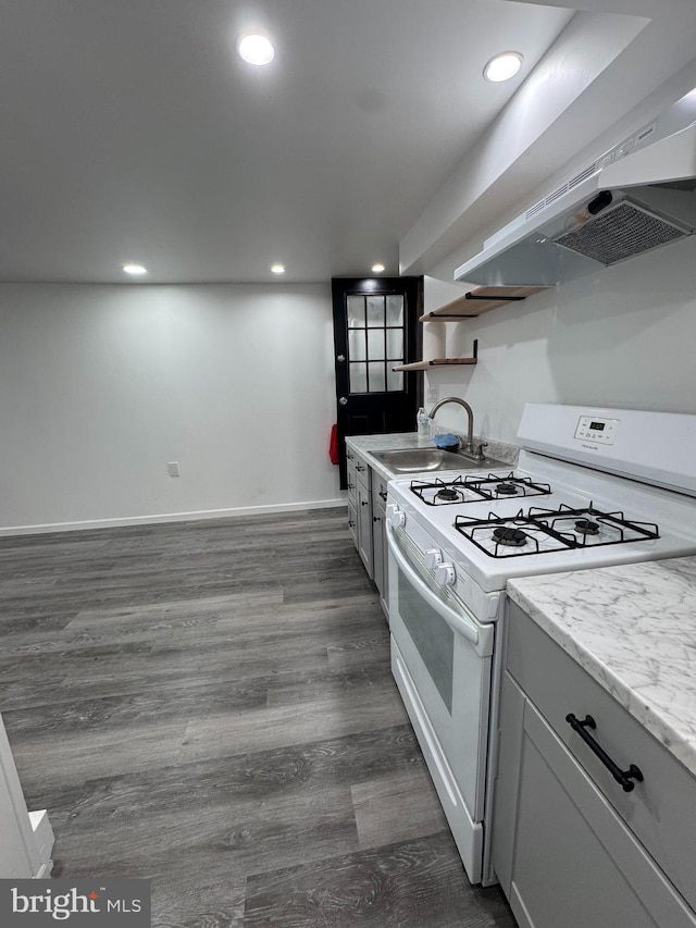 kitchen with white gas range oven, a sink, range hood, dark wood finished floors, and open shelves