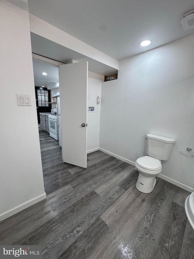 bathroom featuring wood finished floors, baseboards, and recessed lighting