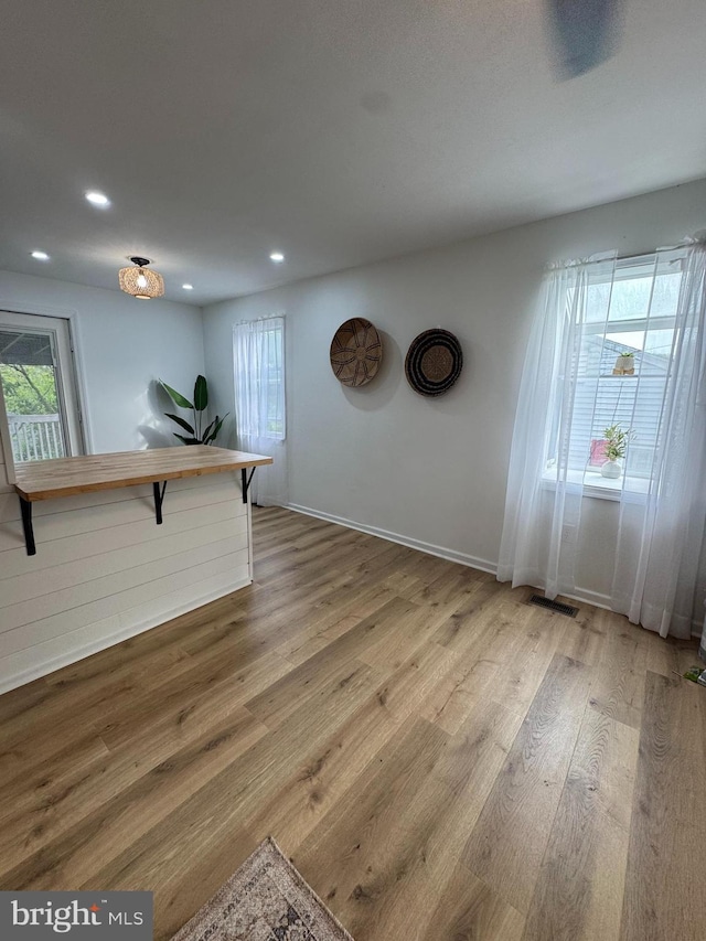 unfurnished room featuring wood finished floors, recessed lighting, and baseboards