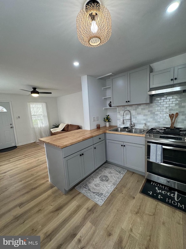 kitchen featuring range with two ovens, wood counters, gray cabinetry, a sink, and recessed lighting