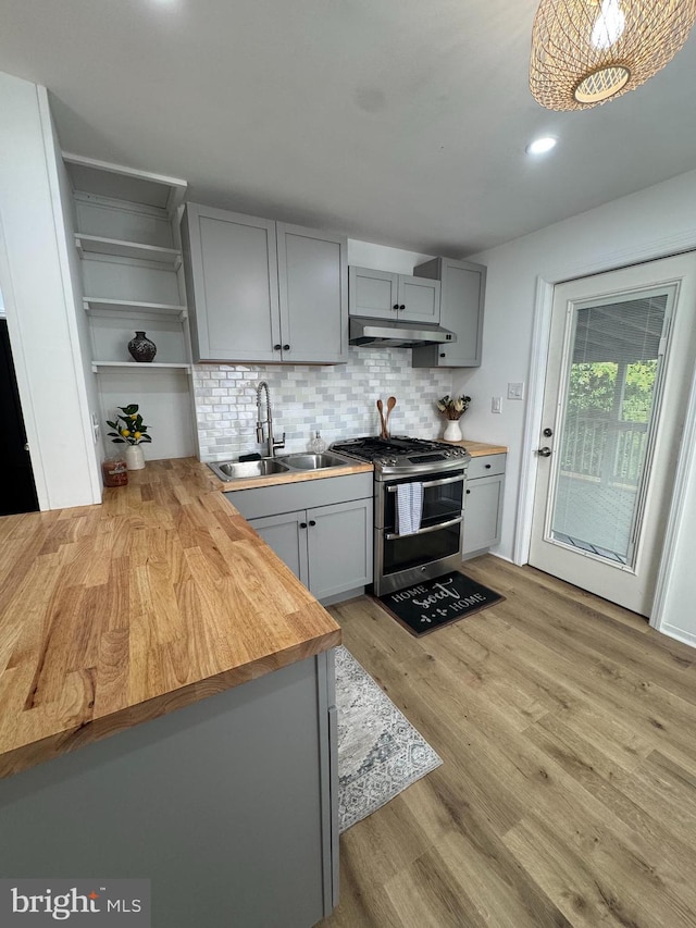 kitchen featuring range with two ovens, a sink, under cabinet range hood, gray cabinets, and wood counters