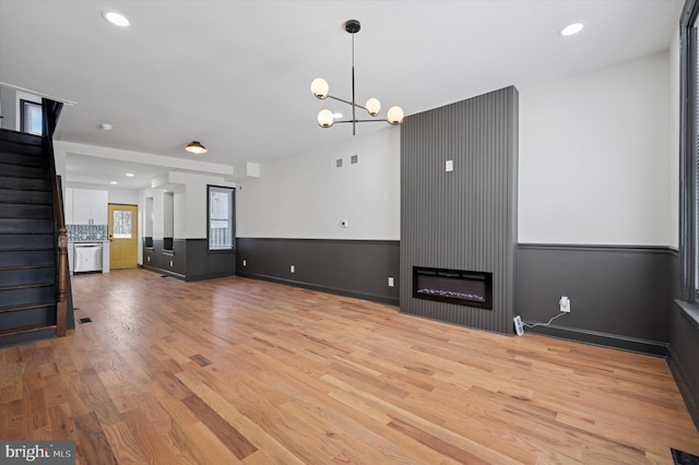 2931 W Susquehanna Ave, Philadelphia, PA 19121 - unfurnished living room featuring a notable chandelier, light wood-style floors, stairs, and recessed lighting