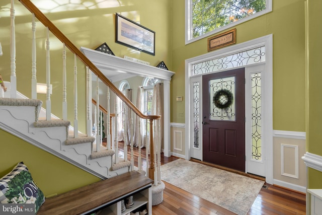 19009 Old Baltimore Rd, Brookeville, MD 20833 - entrance foyer featuring wainscoting, a decorative wall, hardwood / wood-style floors, stairs, and a towering ceiling