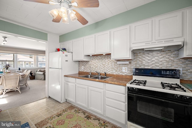 12506 Assawoman Dr, Ocean City, MD 21842 - kitchen with under cabinet range hood, a sink, freestanding refrigerator, range with gas stovetop, and white cabinetry