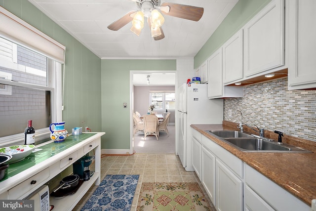 12506 Assawoman Dr, Ocean City, MD 21842 - kitchen featuring backsplash, white cabinetry, a sink, and freestanding refrigerator