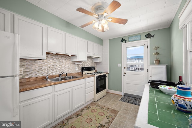 12506 Assawoman Dr, Ocean City, MD 21842 - kitchen featuring white cabinets, a sink, freestanding refrigerator, gas stove, and under cabinet range hood