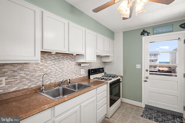 12506 Assawoman Dr, Ocean City, MD 21842 - kitchen with a sink, white cabinetry, gas range, ceiling fan, and under cabinet range hood