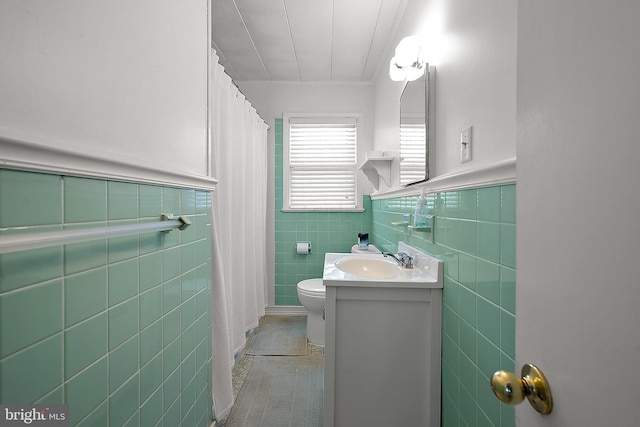 12506 Assawoman Dr, Ocean City, MD 21842 - bathroom featuring crown molding, vanity, tile walls, a wainscoted wall, and toilet