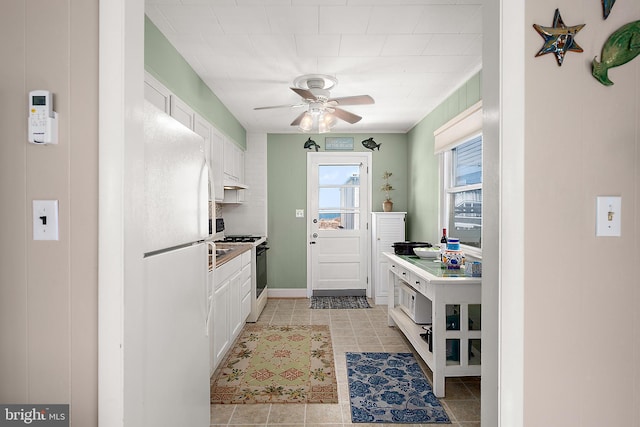12506 Assawoman Dr, Ocean City, MD 21842 - kitchen with white cabinets, a ceiling fan, white appliances, and light tile patterned floors