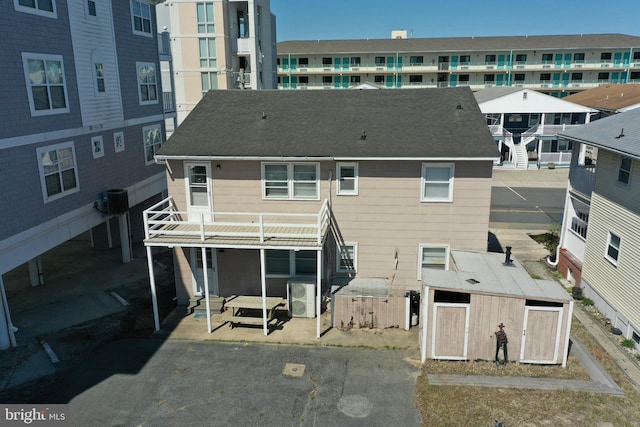 12506 Assawoman Dr, Ocean City, MD 21842 - rear view of property with ac unit, an outdoor structure, roof with shingles, and a shed