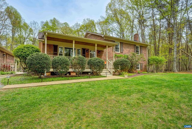 4045 Buck Island Rd, Charlottesville, VA 22902 - view of front facade featuring brick siding, a front yard, a chimney, and covered porch