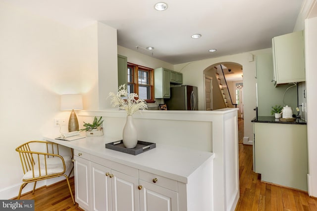 6218 30th St NW, Washington, DC 20015 - kitchen featuring freestanding refrigerator, arched walkways, light wood-type flooring, recessed lighting, and a peninsula