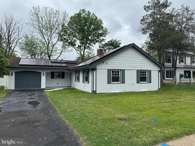 151 Pageant Ln, Willingboro, NJ 08046 - view of front of property featuring a garage, solar panels, a chimney, asphalt driveway, and a front yard
