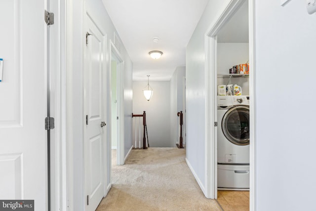 laundry area featuring baseboards, washer / dryer, laundry area, and light colored carpet