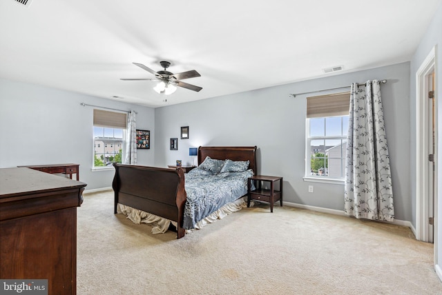 bedroom featuring visible vents, ceiling fan, light colored carpet, and baseboards