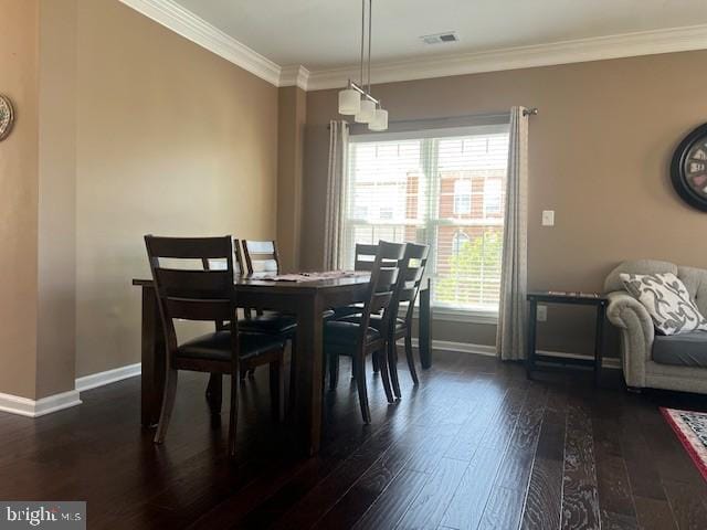 dining room featuring baseboards, visible vents, ornamental molding, and dark wood-type flooring