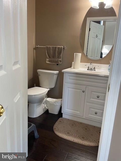 bathroom featuring vanity, wood finished floors, and toilet