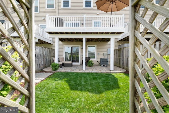 rear view of property featuring cooling unit, a patio, a yard, and a fenced backyard