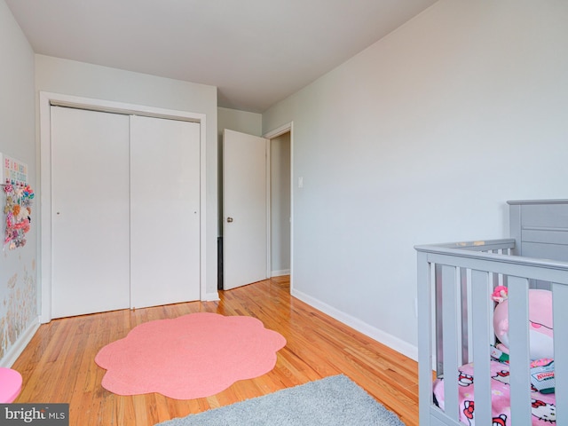 bedroom featuring baseboards, wood finished floors, and a closet