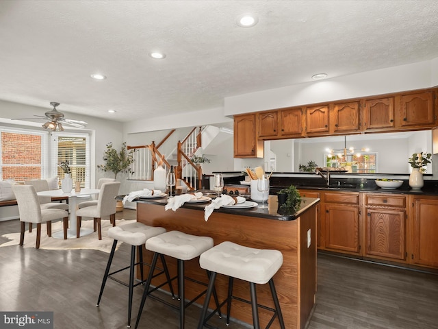 2828 Quarry Heights Way, Baltimore, MD 21209 - kitchen with brown cabinetry, a kitchen breakfast bar, dark wood-style floors, recessed lighting, and a textured ceiling